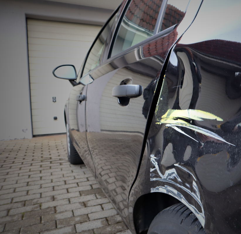 Schwarzes Fahrzeug mit eingedellter Seitenwand